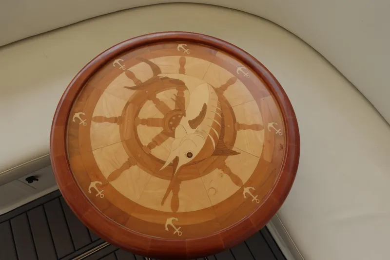 Slide: The Image of Round wooden table with marlin and anchor inlay design on a Carolina Classic 35 boat. - 29
