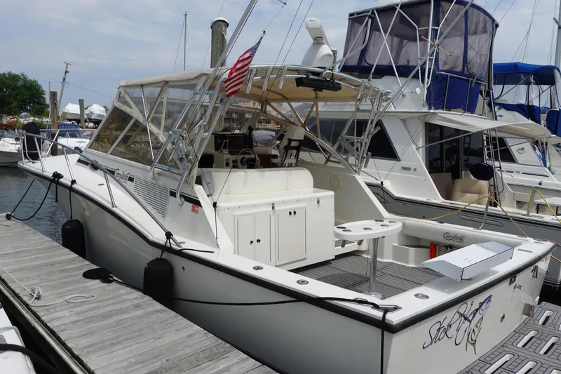 Slide: The Image of 2002 Carolina Classic 35 boat docked at marina with American flag. - 3