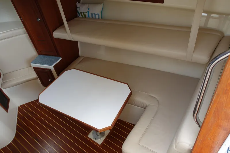 Slide: The Image of 2002 Carolina Classic 35 interior with beige seating, wooden flooring, and a white table. - 31