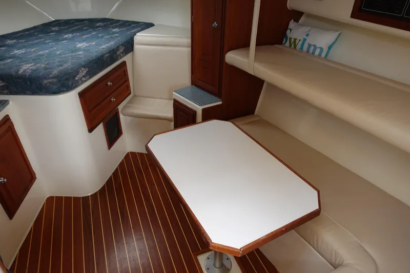 Slide: The Image of 2002 Carolina Classic 35 cabin interior with wood flooring, table, and seating area. - 32