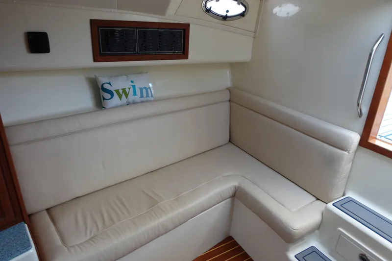 Slide: The Image of 2002 Carolina Classic 35 interior with beige seating and "Swim" pillow. - 34