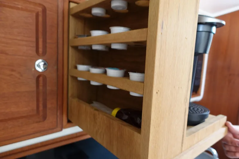 Slide: The Image of Wooden cabinet with coffee pod storage in a 2002 Carolina Classic 35 boat. - 37