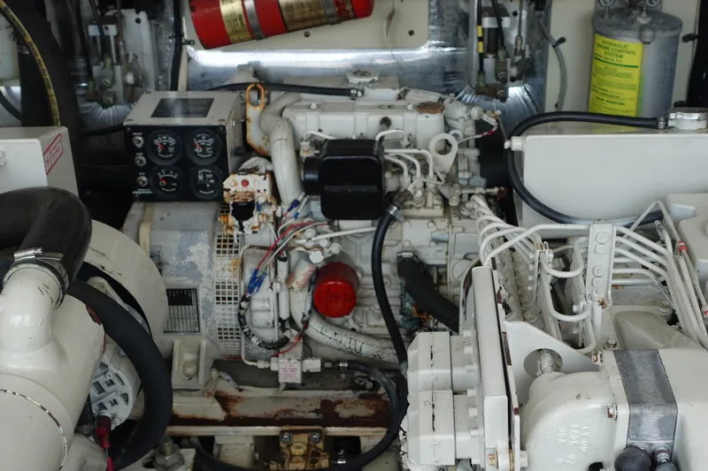 Slide: The Image of Engine room of a 2002 Carolina Classic 35 boat, featuring mechanical components and fire extinguisher. - 43