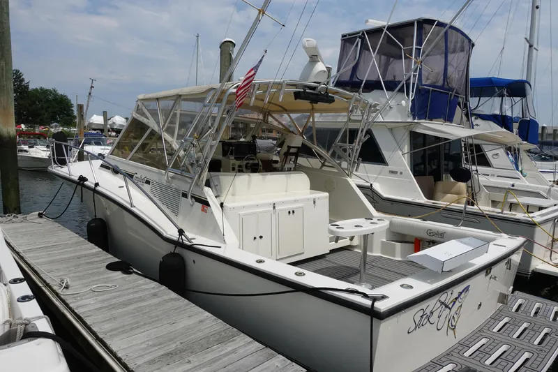 Slide: The Image of 2002 Carolina Classic 35 boat docked at marina with American flag. - 6