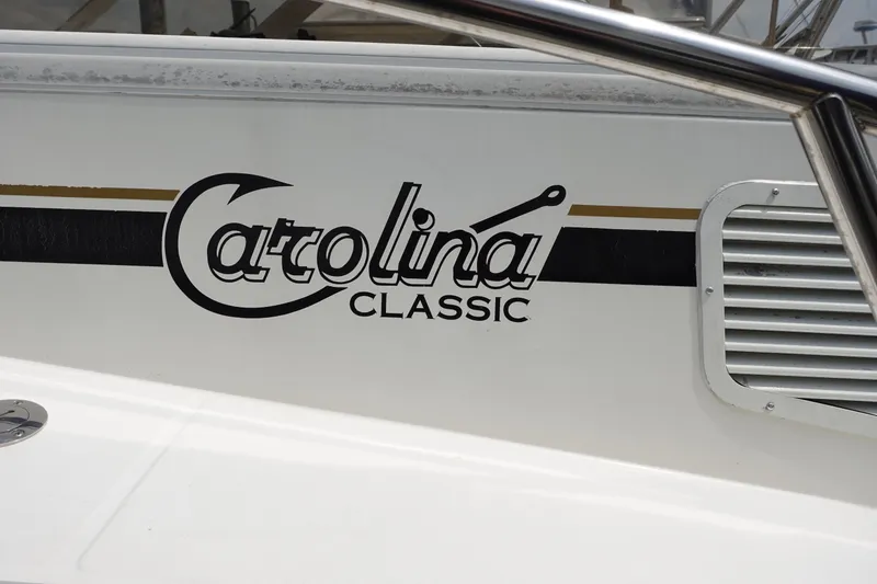 Slide: The Image of 2002 Carolina Classic 35 boat logo on white hull with black and gold accents. - 7