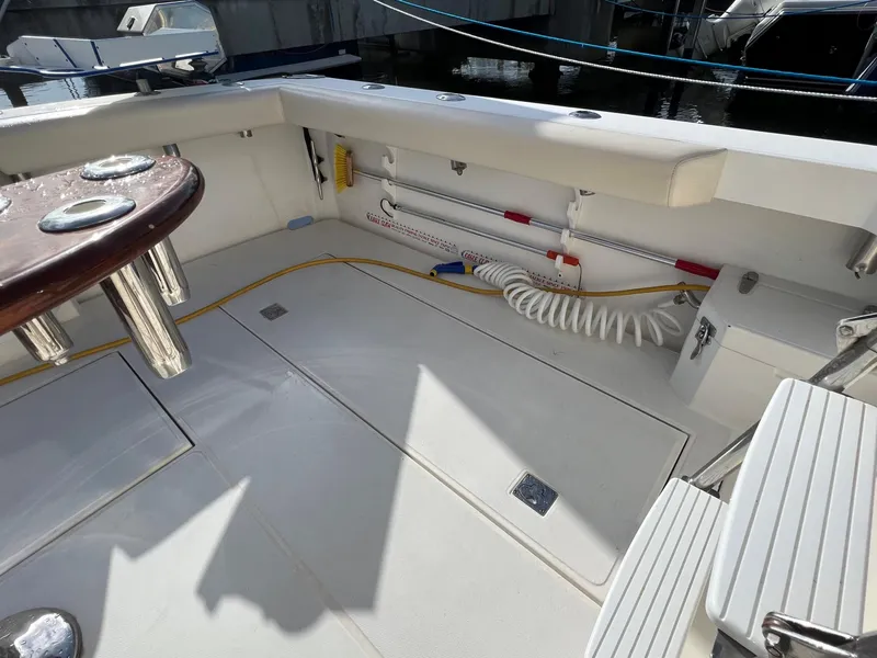 Slide: The Image of Cabo 35 Flybridge Sportfisher 2000 model boat deck with fishing rod holders and storage compartments. - 16