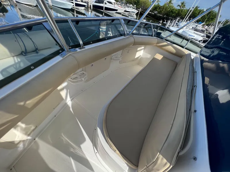 Slide: The Image of 2000 Cabo 35 Flybridge Sportfisher boat interior with beige seating and docked boats in background. - 19