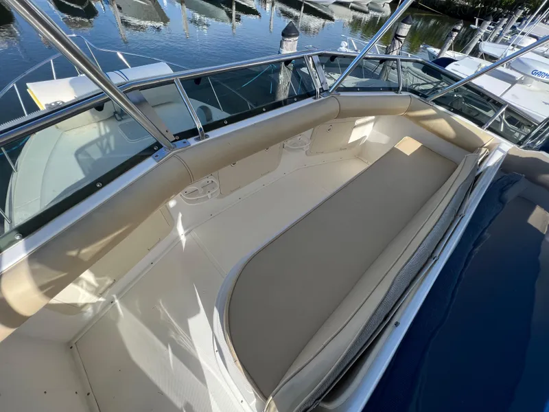 Slide: The Image of Cabo 35 Flybridge Sportfisher 2000 boat deck with cushioned seating, docked at marina. - 20