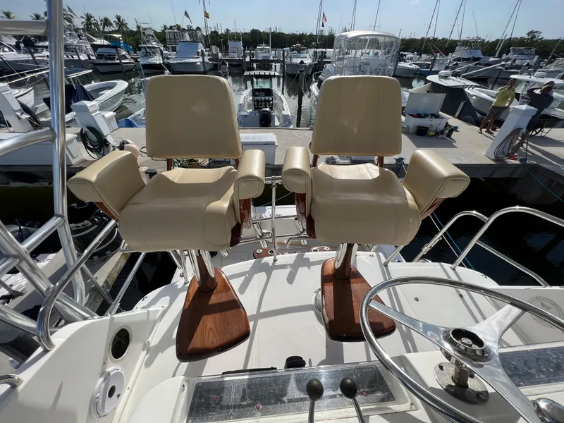 Slide: The Image of Two captain chairs on a 2000 Cabo 35 Flybridge Sportfisher at a marina. - 22