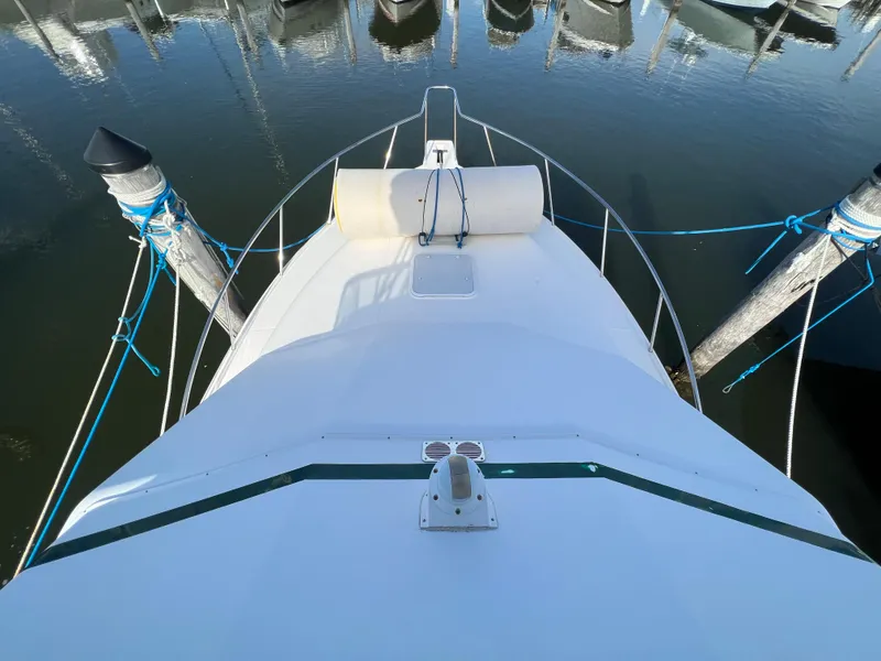 Slide: The Image of View from the bow of a 2000 Cabo 35 Flybridge Sportfisher docked at a marina. - 23