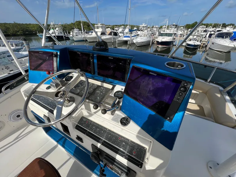 Slide: The Image of 2000 Cabo 35 Flybridge Sportfisher helm with advanced navigation systems at marina. - 28