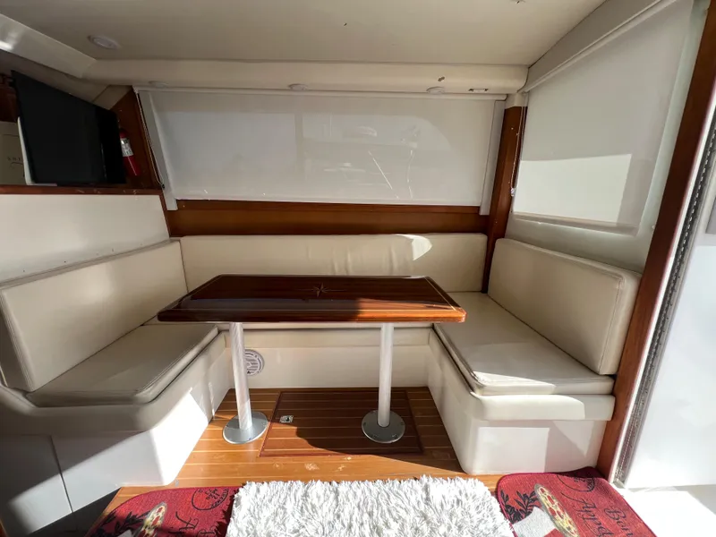 Slide: The Image of Interior of 2000 Cabo 35 Flybridge Sportfisher with dining area and wooden table. - 38