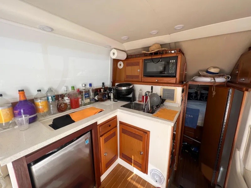 Slide: The Image of Compact kitchen area in a 2000 Cabo 35 Flybridge Sportfisher boat with appliances and storage. - 39