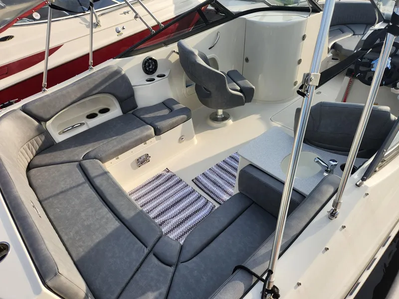 Slide: The Image of 2022 Stingray 231 DC boat interior with gray seating and striped mats. - 10