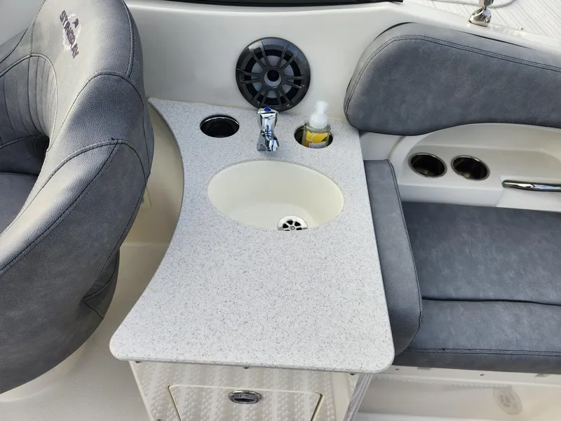 Slide: The Image of 2022 Stingray 231 DC boat interior with sink, cup holders, and seating. - 12