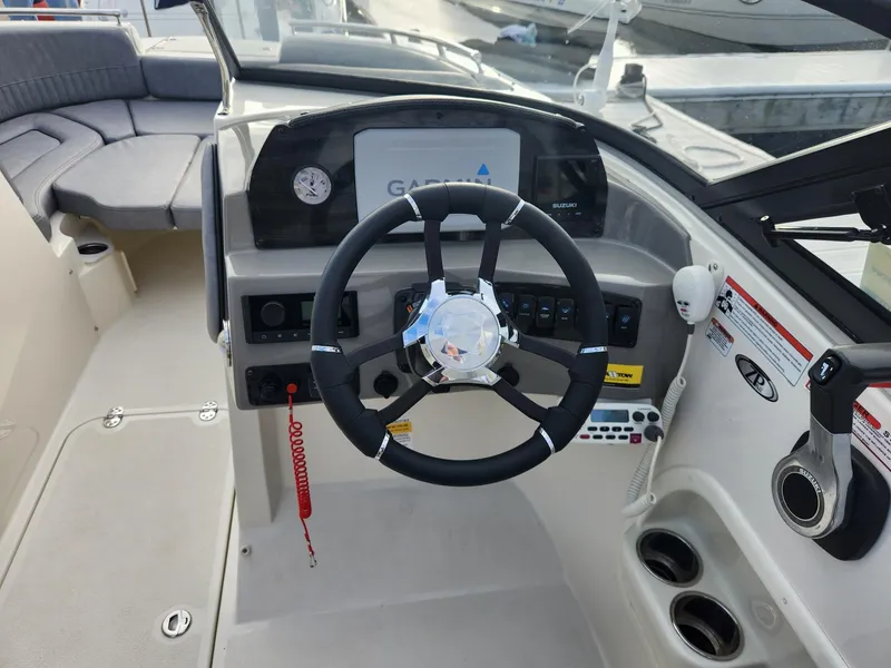 Slide: The Image of 2022 Stingray 231 DC boat cockpit with steering wheel and control panel. - 17