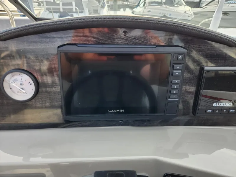 Slide: The Image of Dashboard of 2022 Stingray 231 DC boat with Garmin display and Suzuki gauge. - 18