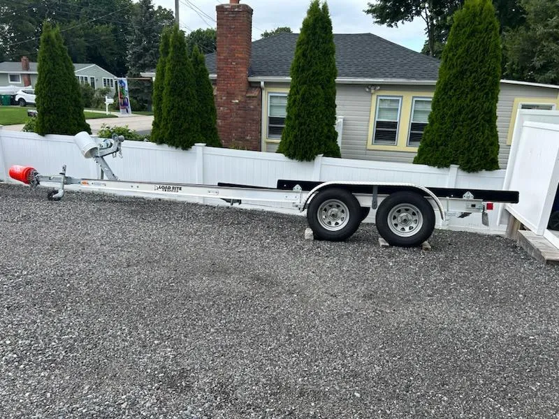 Slide: The Image of Trailer for 2022 Stingray 231 DC boat parked on gravel driveway. - 24