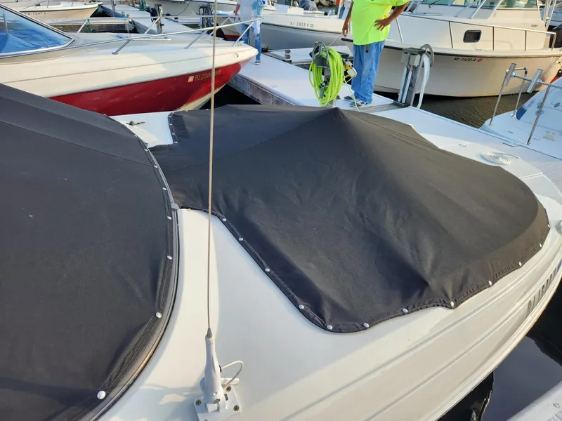 Slide: The Image of 2022 Stingray 231 DC boat with black cover docked at marina. - 3