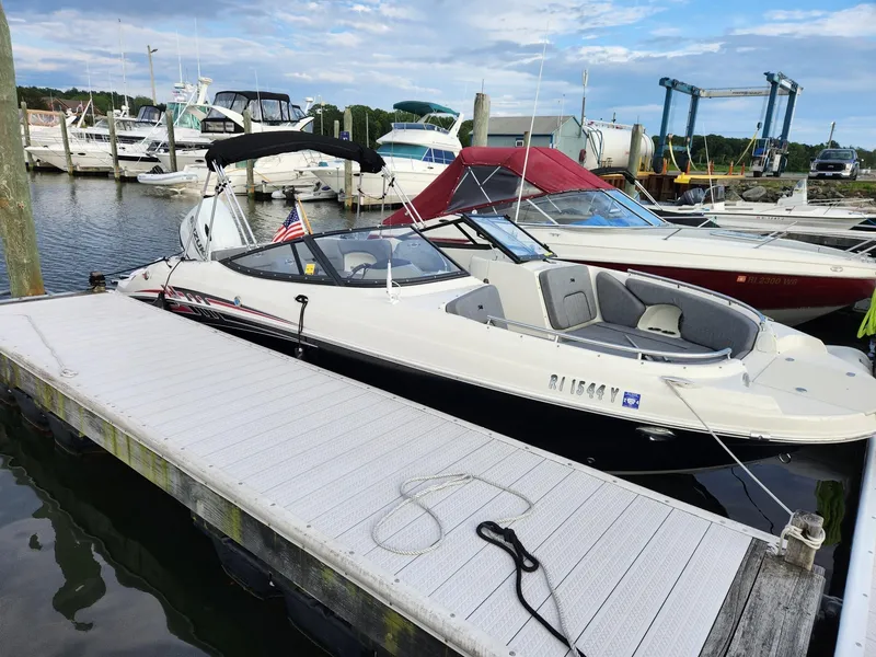Slide: The Image of 2022 Stingray 231 DC boat docked at a marina with other vessels. - 5