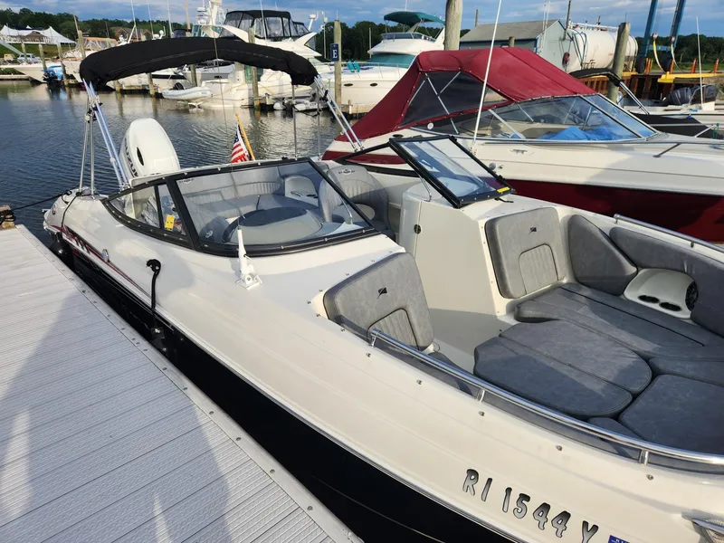 Slide: The Image of 2022 Stingray 231 DC boat docked at marina, featuring sleek design and comfortable seating. - 6