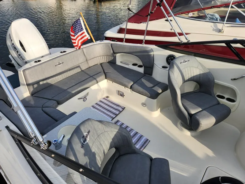 Slide: The Image of 2022 Stingray 231 DC boat interior with gray seating and American flag. - 7