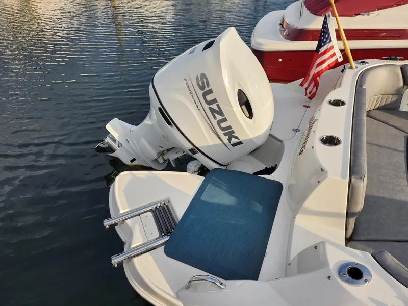 Slide: The Image of 2022 Stingray 231 DC boat with Suzuki outboard motor and American flag on water. - 8
