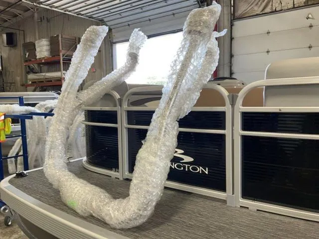 Slide: The Image of 2025 Bennington 20 SVL pontoon boat in a garage, partially wrapped in bubble wrap. - 17