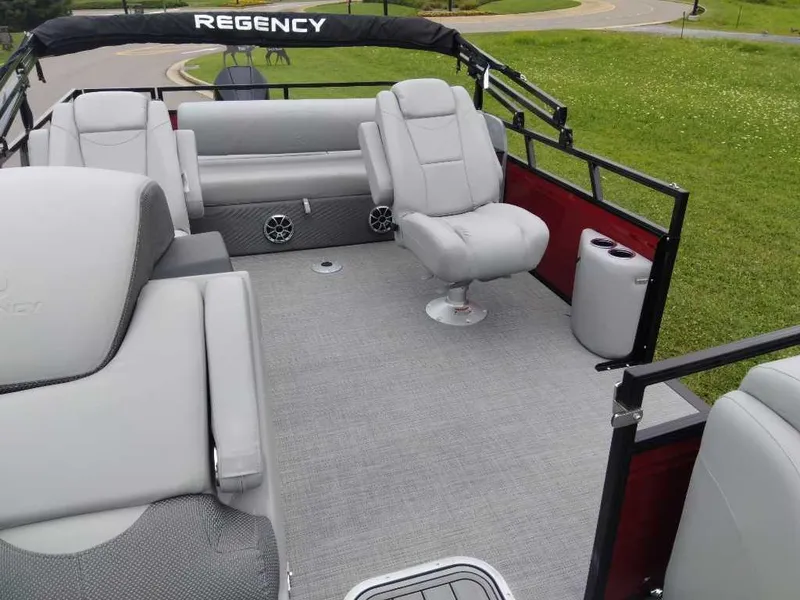 Slide: The Image of 2024 Regency 250 DL3 pontoon boat interior with gray seating and spacious deck. - 5