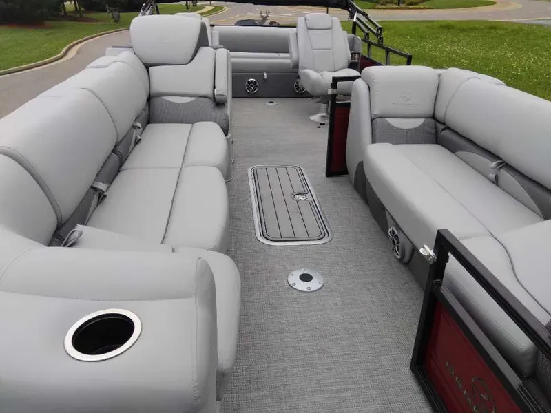Slide: The Image of 2024 Regency 250 DL3 pontoon boat with spacious gray seating and cup holders. - 7