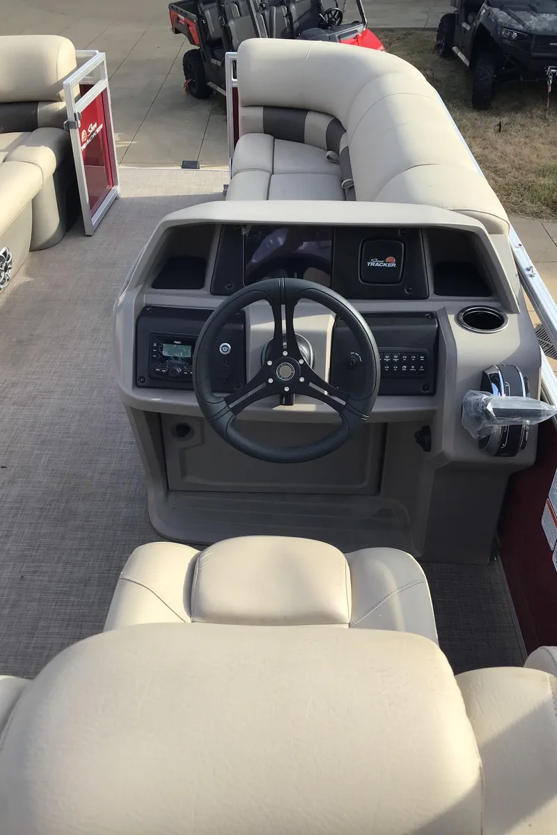 Slide: The Image of 2024 Sun Tracker Party Barge 20 DLX interior with steering wheel and seating. - 4