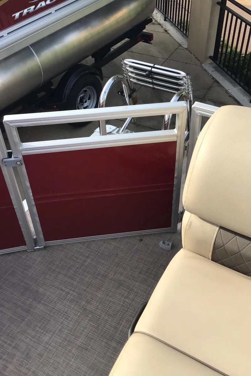 Slide: The Image of 2024 Sun Tracker Party Barge 20 DLX interior with beige seating and red paneling. - 6