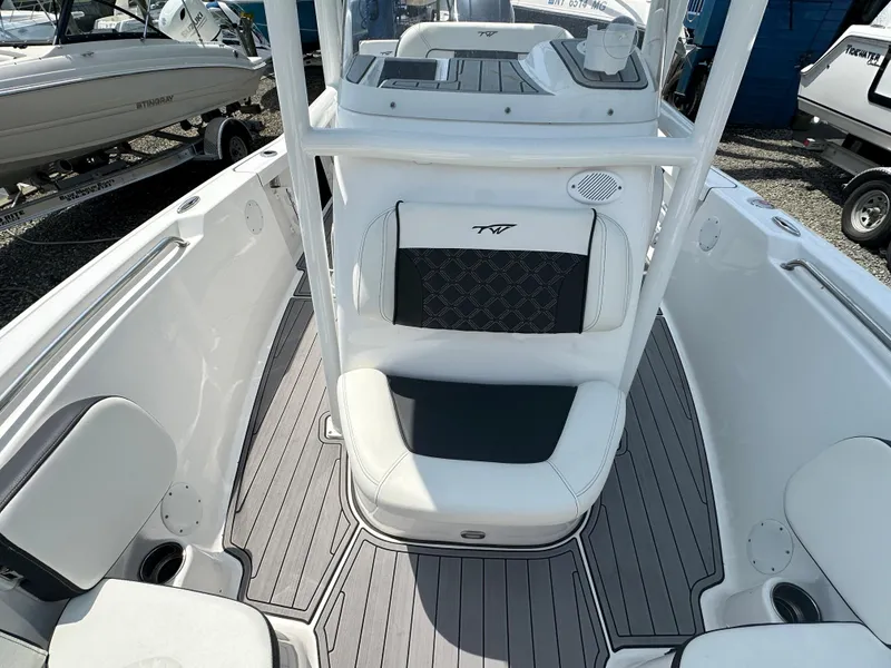 Slide: The Image of 2022 Tidewater 198 CC boat interior with white and gray seating and flooring. - 10
