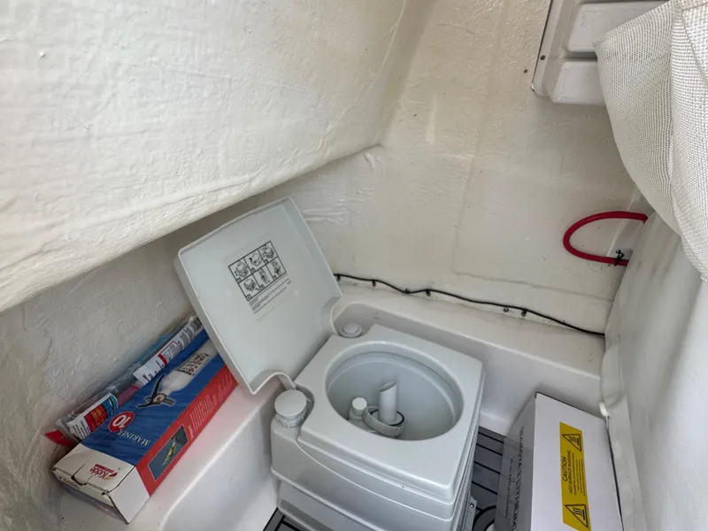 Slide: The Image of 2022 Tidewater 198 CC boat interior with portable toilet and storage area. - 21