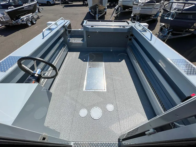 Slide: The Image of 2023 Hewescraft 240 Ocean Pro HT boat interior, spacious deck, steering wheel, and storage compartments. - 13