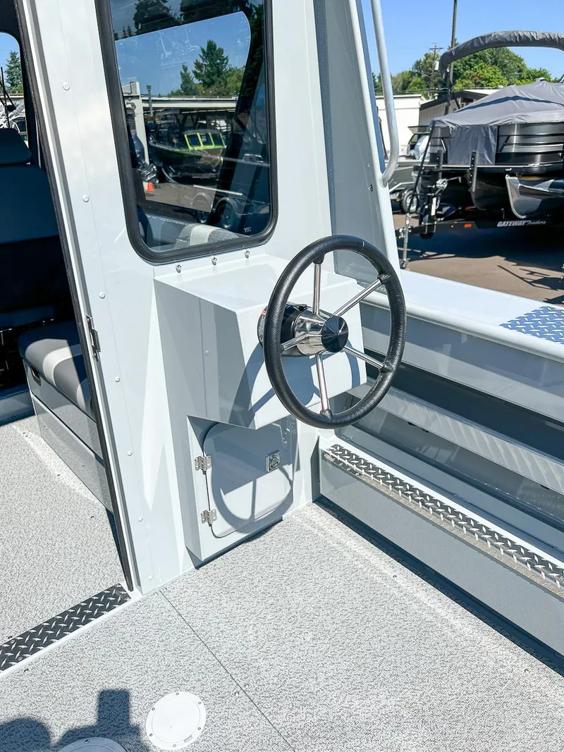 Slide: The Image of 2023 Hewescraft 240 Ocean Pro HT boat interior with steering wheel and window. - 18