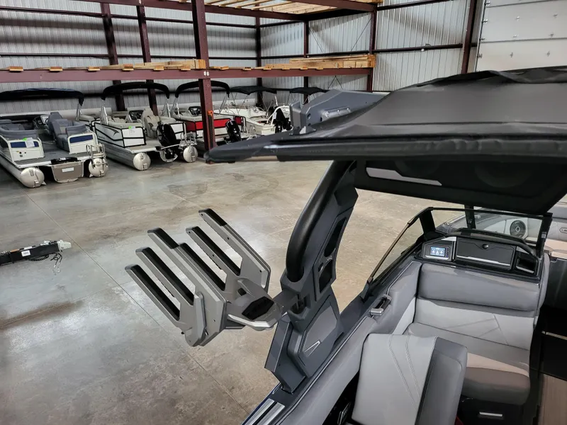 Slide: The Image of 2024 Supra SL boat interior with wakeboard rack in a storage facility. - 11