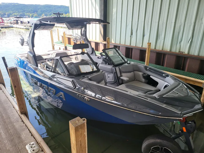 Slide: The Image of 2024 Supra SL boat docked in marina, blue and gray exterior. - 20
