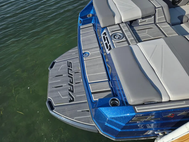 Slide: The Image of 2024 Supra SL boat with sleek blue and gray design on water. - 35