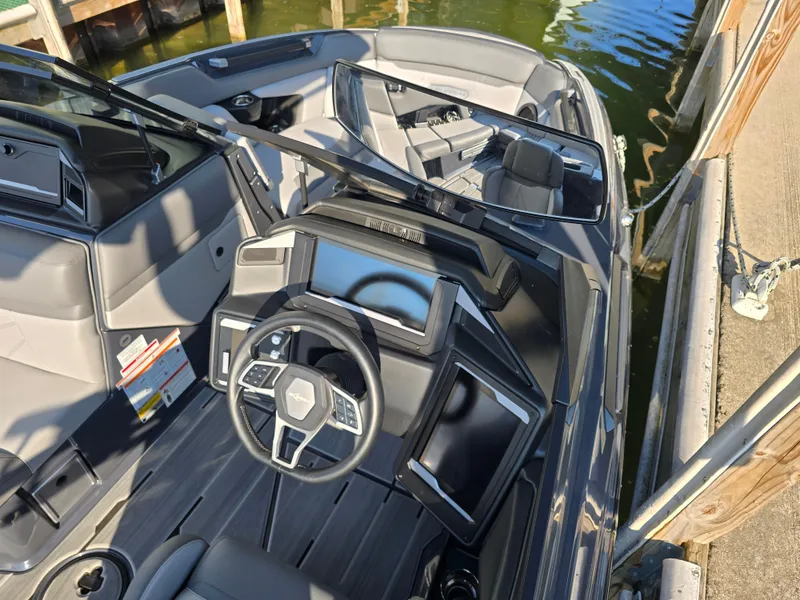 Slide: The Image of 2024 Supra SL boat interior with modern dashboard and steering wheel, docked by the water. - 38