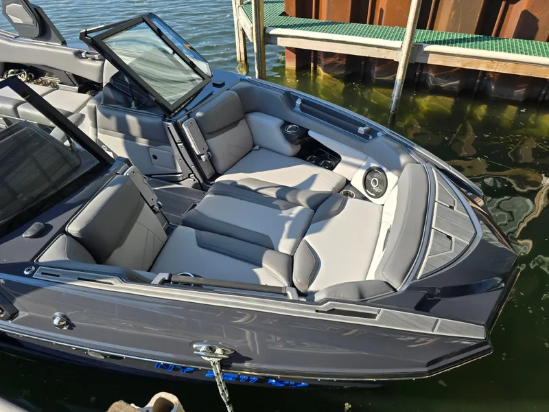 Slide: The Image of 2024 Supra SL boat with luxurious seating, docked on calm water. - 39
