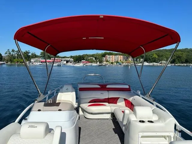 Slide: The Image of 2023 JC SportToon 24 TT pontoon boat with red canopy on a lake. - 19