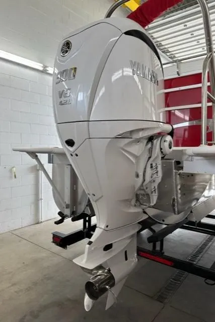 Slide: The Image of 2023 JC SportToon 24 TT with Yamaha V6 outboard motor in a garage. - 33