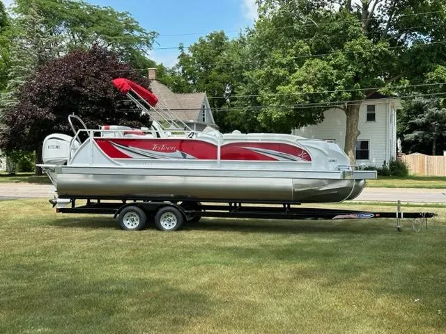 Slide: The Image of 2023 JC SportToon 24 TT pontoon boat on a trailer in a residential area. - 31
