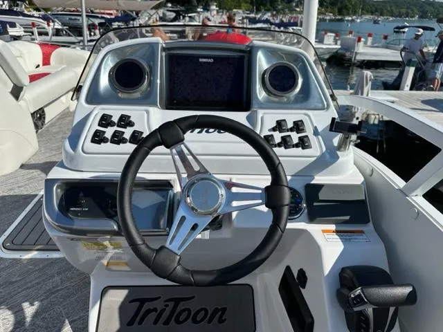 Slide: The Image of 2023 JC SportToon 24 TT boat dashboard with steering wheel and control panel. - 7