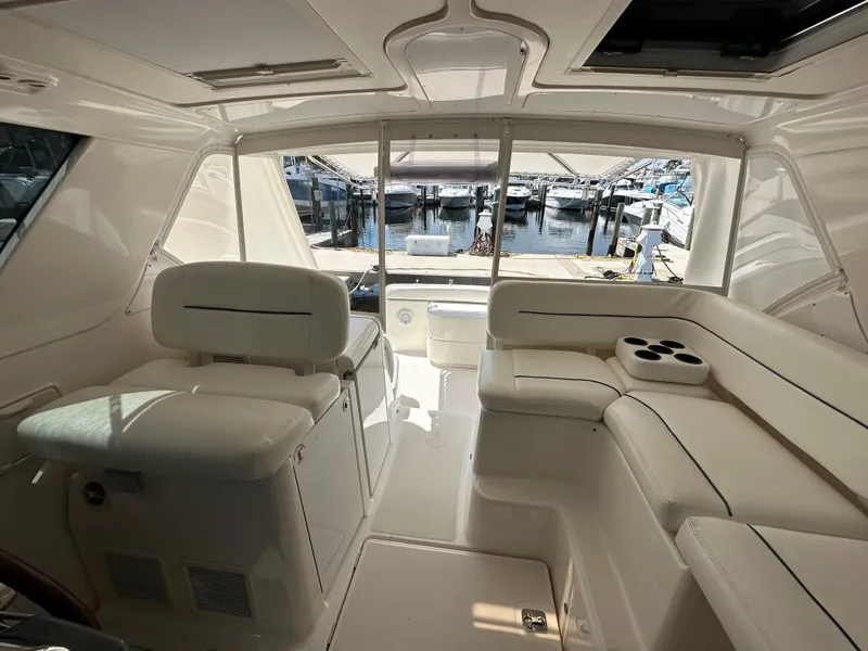Slide: The Image of Interior of a 2004 Tiara Yachts 3600 Sovran, featuring white seating and a view of the marina. - 11