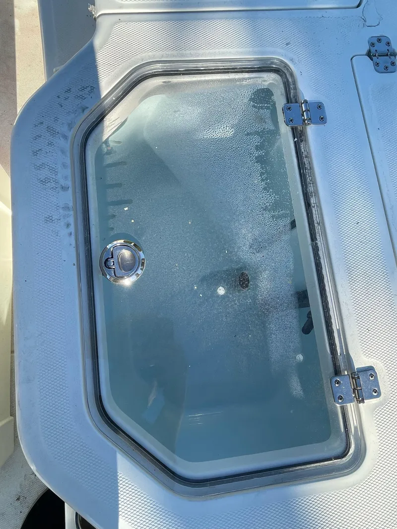 Slide: The Image of 2023 Mako Pro Skiff 19 CC livewell with clear lid and secure latch. - 10