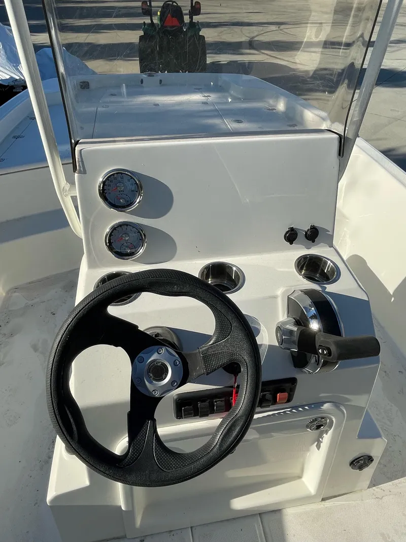 Slide: The Image of 2023 Mako Pro Skiff 19 CC boat console with steering wheel and controls. - 6