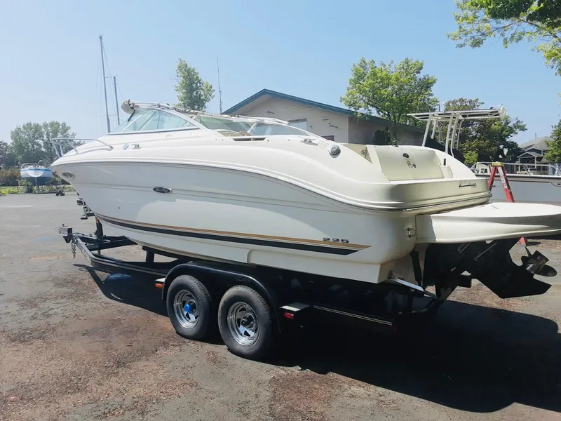 The Image of 2001 Sea Ray 225 Weekender boat on trailer, parked outdoors. - 0