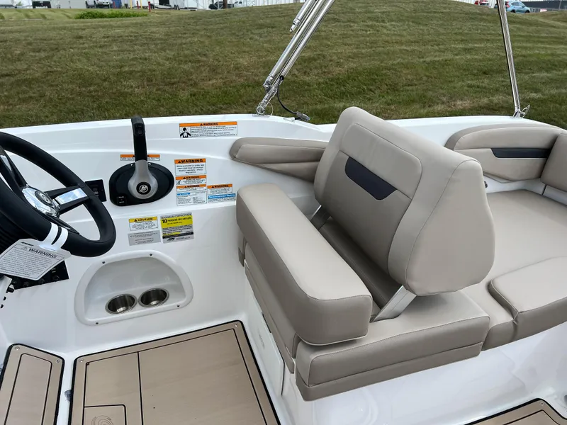 Slide: The Image of 2024 Hurricane SunDeck Sport 205 IO boat interior with beige seating and steering wheel. - 20